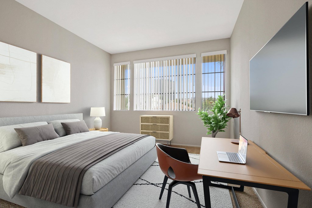a bedroom with a bed and a desk with a laptop at Darlington Apartments, Los Angeles, California