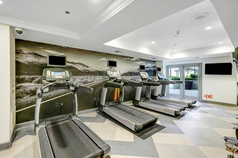 a gym with treadmills and televisions  at Apex Mission Valley, San Diego, California