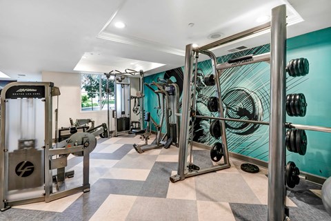 a home gym with a turquoise wall and a checkered floor  at Apex Mission Valley, San Diego, California