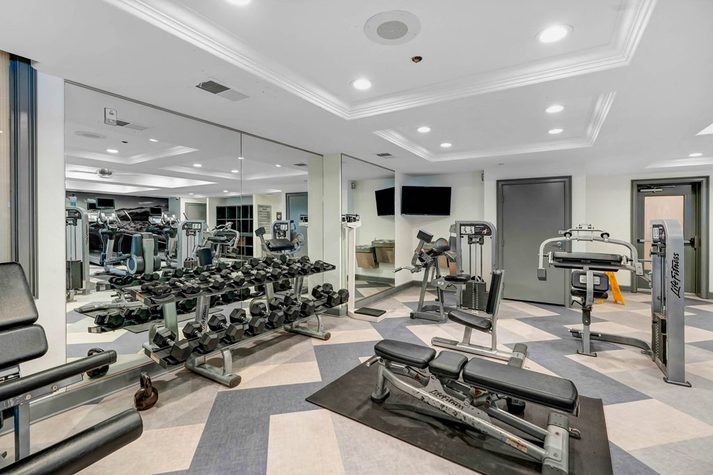 a spacious fitness center with state of the art exercise equipment and mirrors