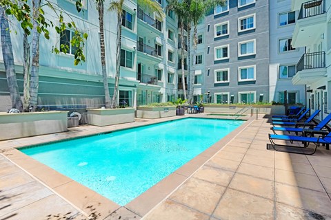 an apartment with a swimming pool in front of a building   at Apex Mission Valley, San Diego, California