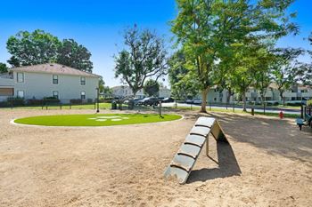 a park with a bench and a grassy area in front of a building at The Park Apartments, Rancho Cucamonga