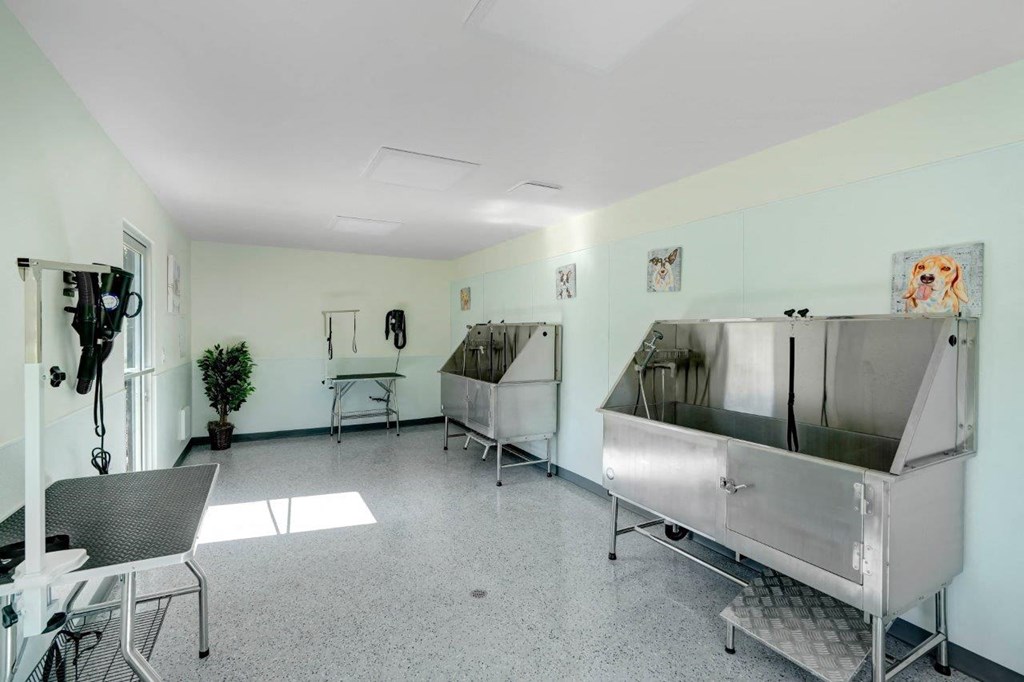 a room with two large stainless steel sinks and a table and chairs