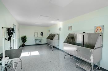 a room with two large stainless steel sinks and a table and chairs at The Park Apartments, California