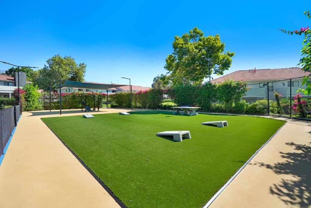a grassy area with a picnic table and benches