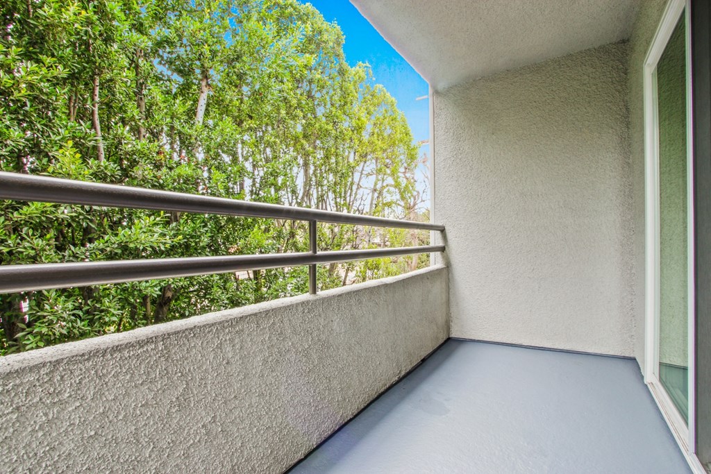 a balcony with a view of trees and a blue sky at Palm Royale Apartments, California, 90034