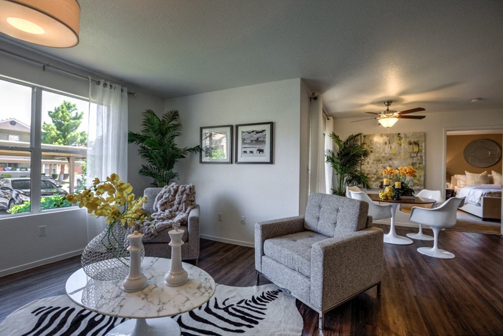 a living room with a table and chairs and a large window at Bella Terra Apartments, Henderson, Nevada