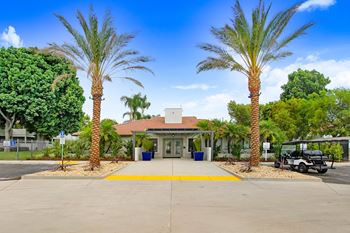 a parking lot with palm trees in front of a building at The Park Apartments, California