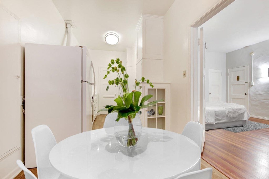 a white table with a vase of flowers on top of it at 1022 Tiverton, Los Angeles, CA