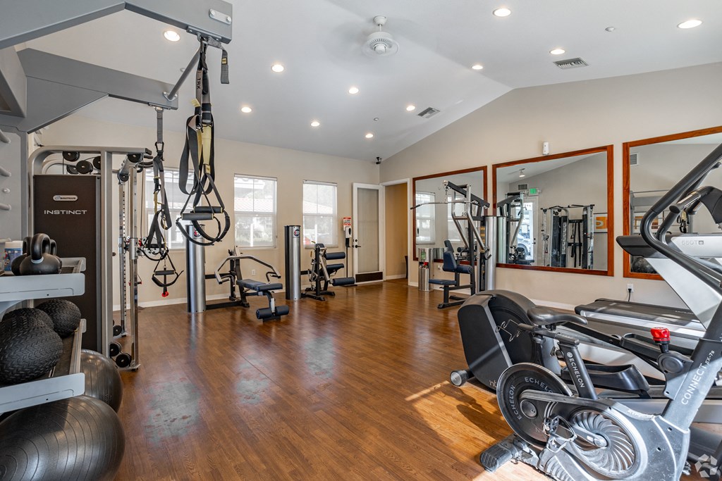 a home gym with exercise equipment and mirrors at Canyon Crest, Riverside, CA