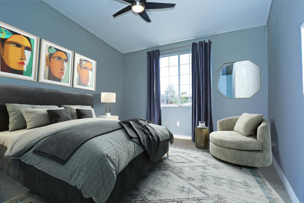 A bedroom with a bed, chair, and artwork on the wall at Milan Apartment Townhomes, Las Vegas, NV, 89183