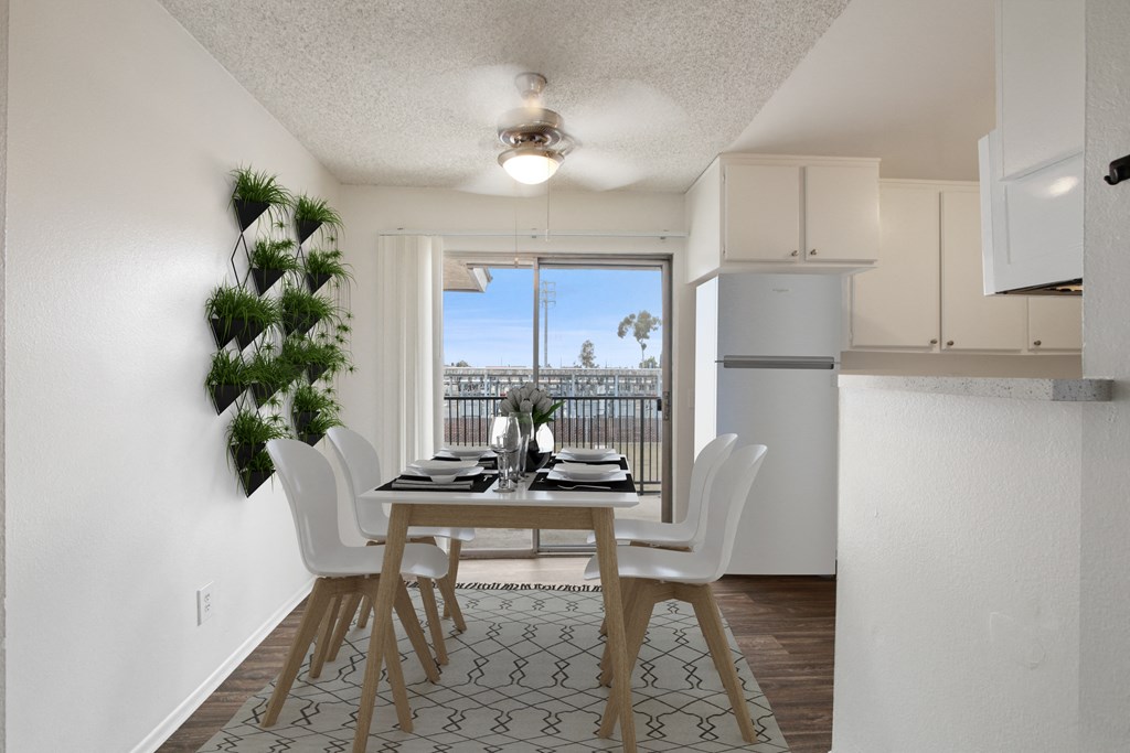 an open kitchen and dining room with a table and chairs and a balcony