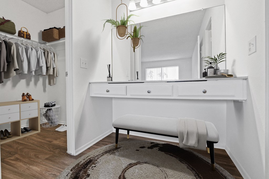 a small dressing room with a white bench and a mirror