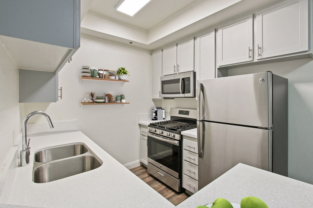 a kitchen with stainless steel appliances and a sink at Palm Royale Apartments, Los Angeles