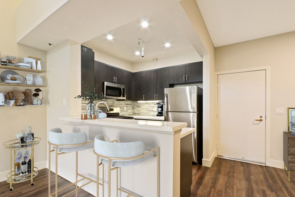 A kitchen with a white island and bar stools at Playa Summit, Los Angeles