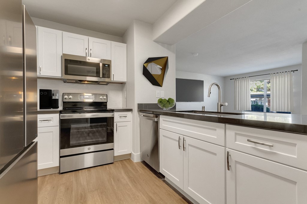 an open kitchen with stainless steel appliances and white cabinets at Bella Terra Apartments, Henderson, 89012