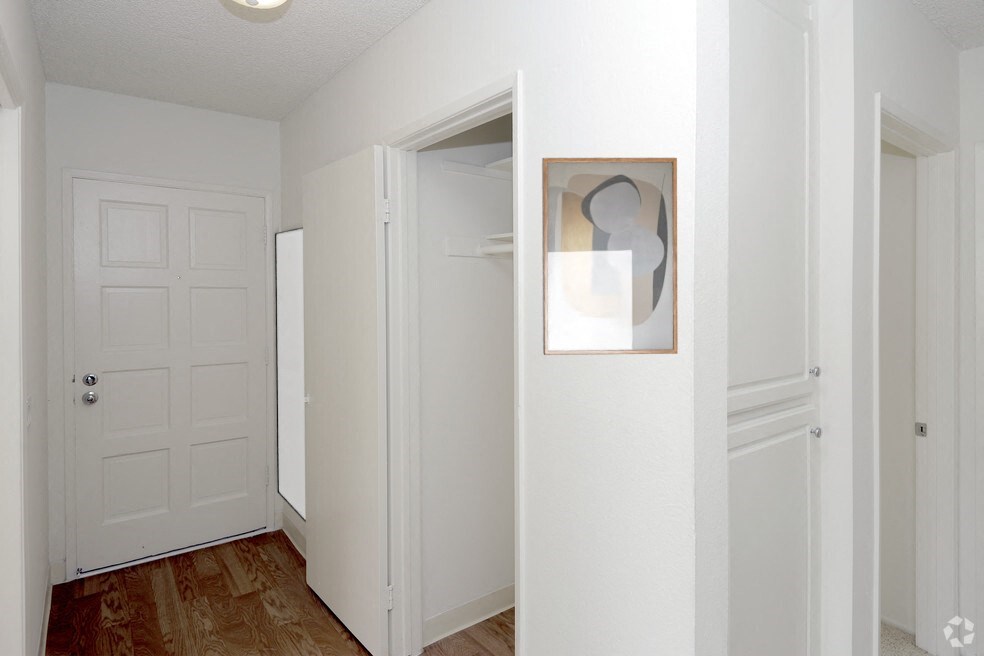 a bedroom with a white door and a painting on the wall