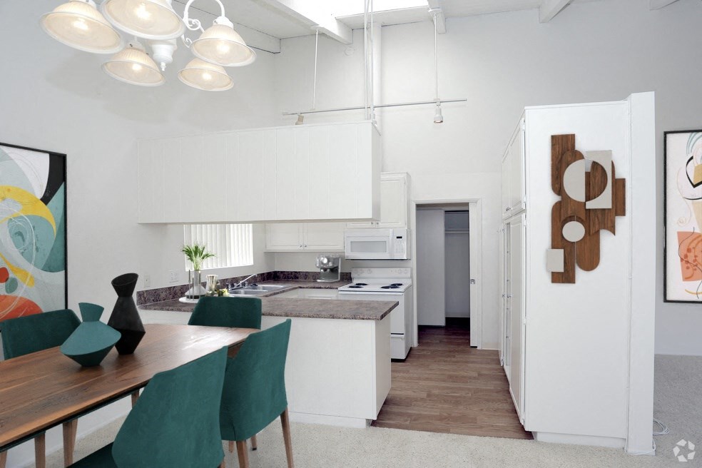 a kitchen and dining room with white cabinets and a table