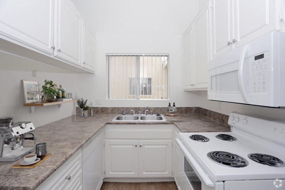 a white kitchen with white appliances and white cabinets