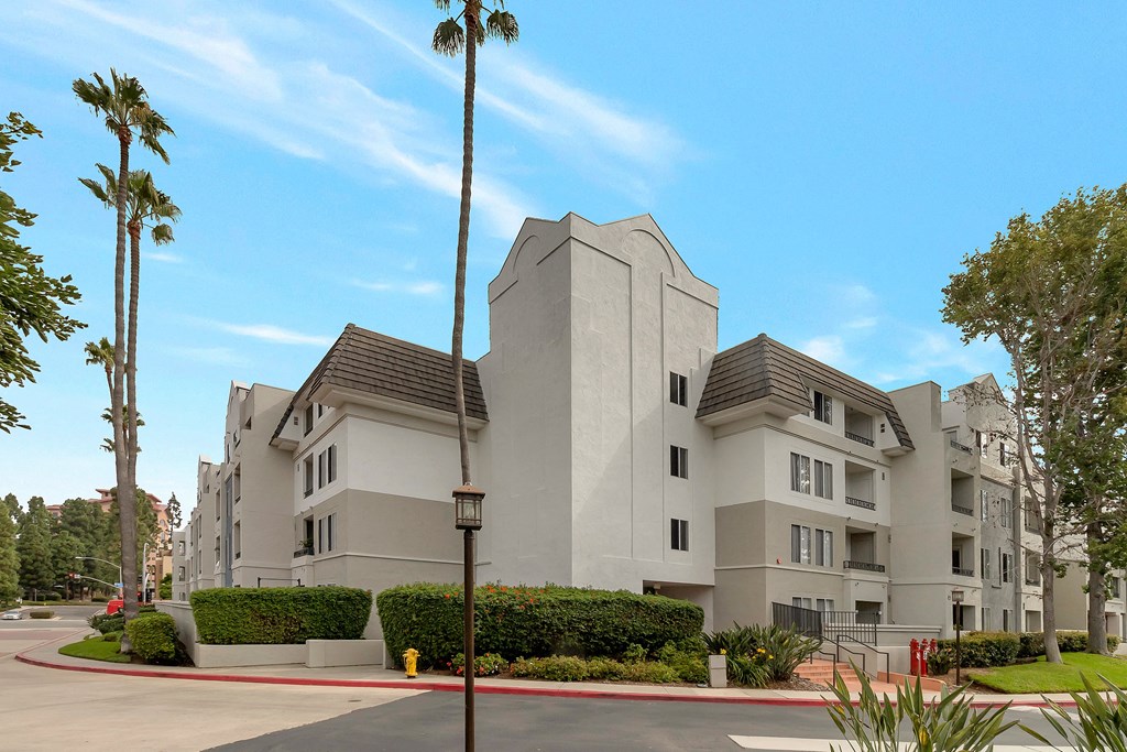 a large white apartment building with palm trees in front of it at Nobel Court, San Diego, CA