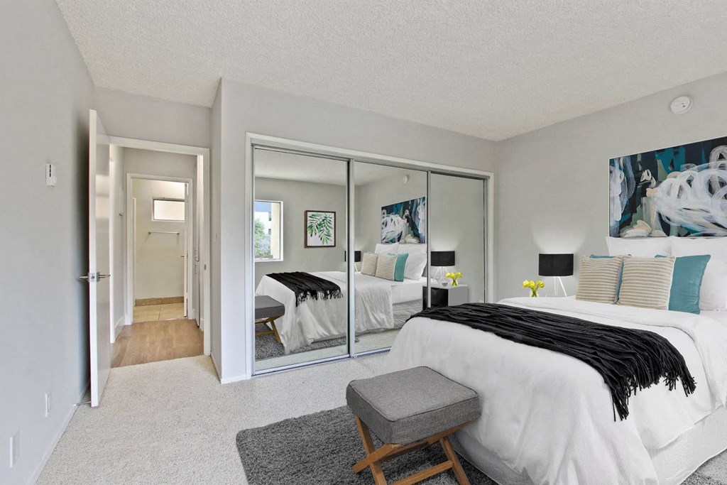 a bedroom with a bed and mirrored closet doors at The Mark Culver City, Culver City, CA