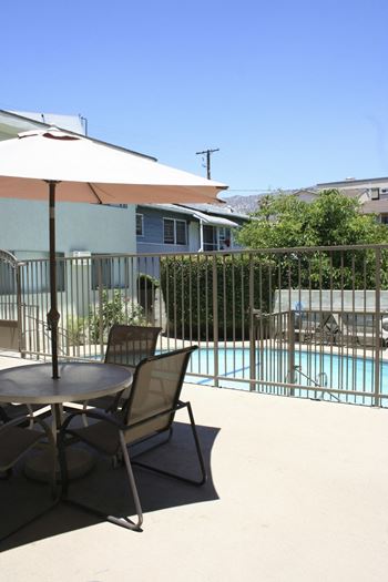 Pool side table chair at Palm Capri Apartments, California, 91501