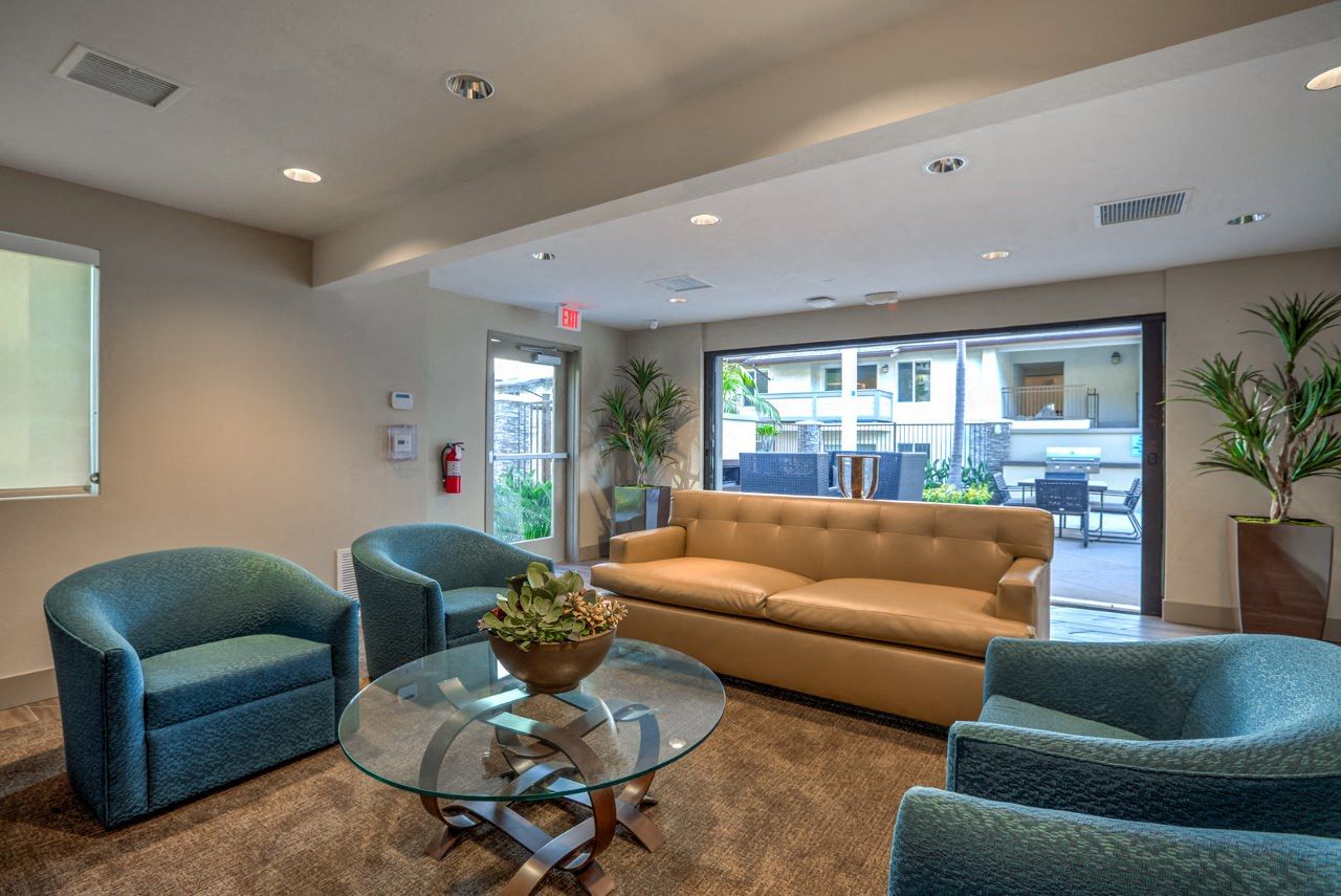 a living room with a couch and chairs and a glass table