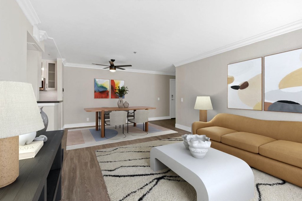 A living room with a brown couch, a white coffee table, and a painting on the wall at Rochester Apartments, California, 90024