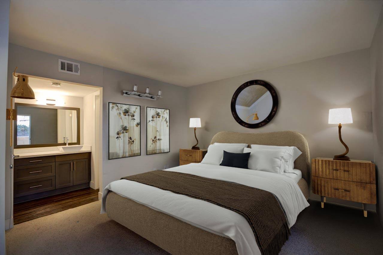 A bedroom with a large bed and a round mirror on the wall.