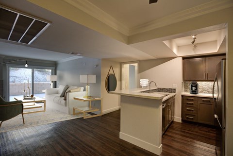 A modern kitchen with a white island and dark wood floors.