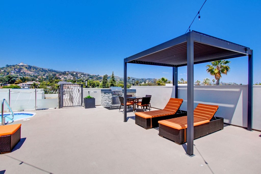 a rooftop patio with a table and chairs and a pool at The Kenmore Los Feliz, Los Angeles, CA