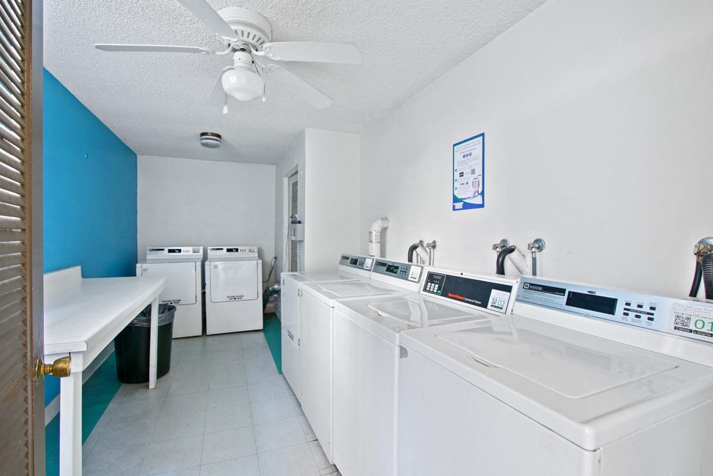 a laundry room with white appliances and a ceiling fan
