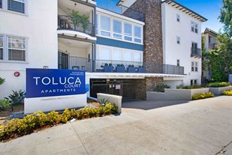 a building with a toluca court apartments sign in front of it at Toluca Court, Toluca Lake, CA