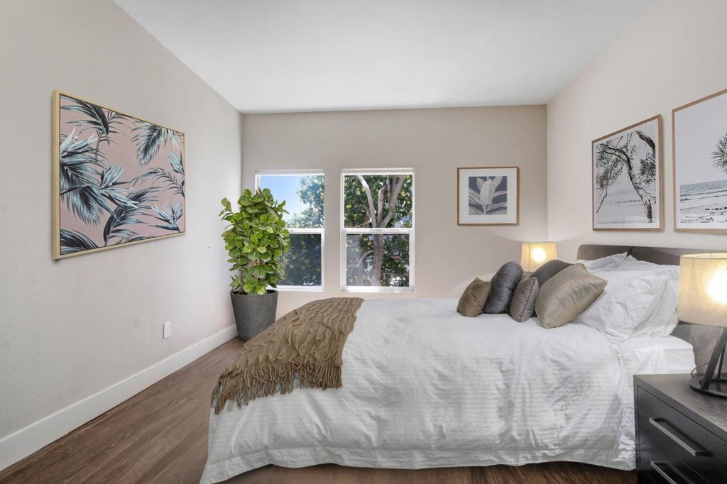 a bedroom with a large bed and three windows at Toluca Court, Toluca Lake, CA