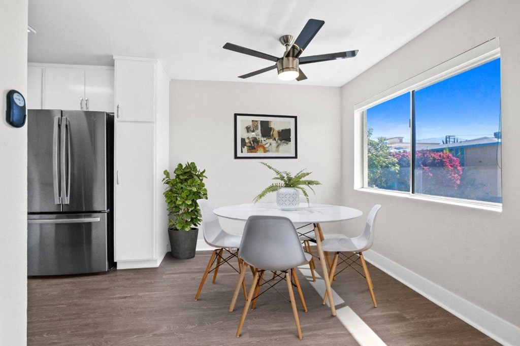 a dining room with a table and chairs and a refrigerator