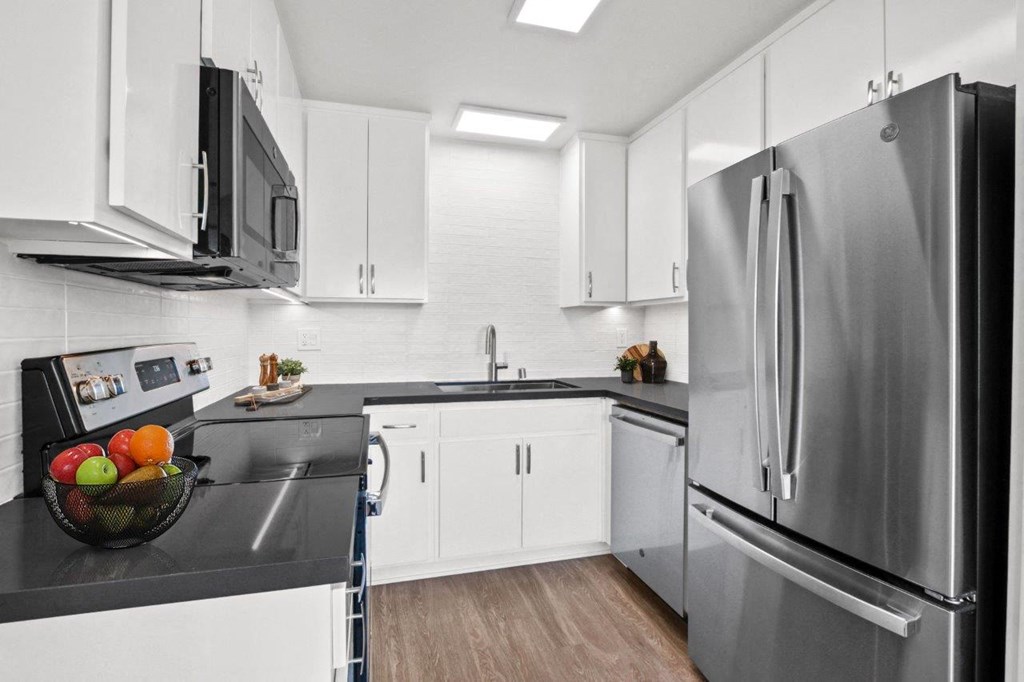 a kitchen with stainless steel appliances and white cabinets