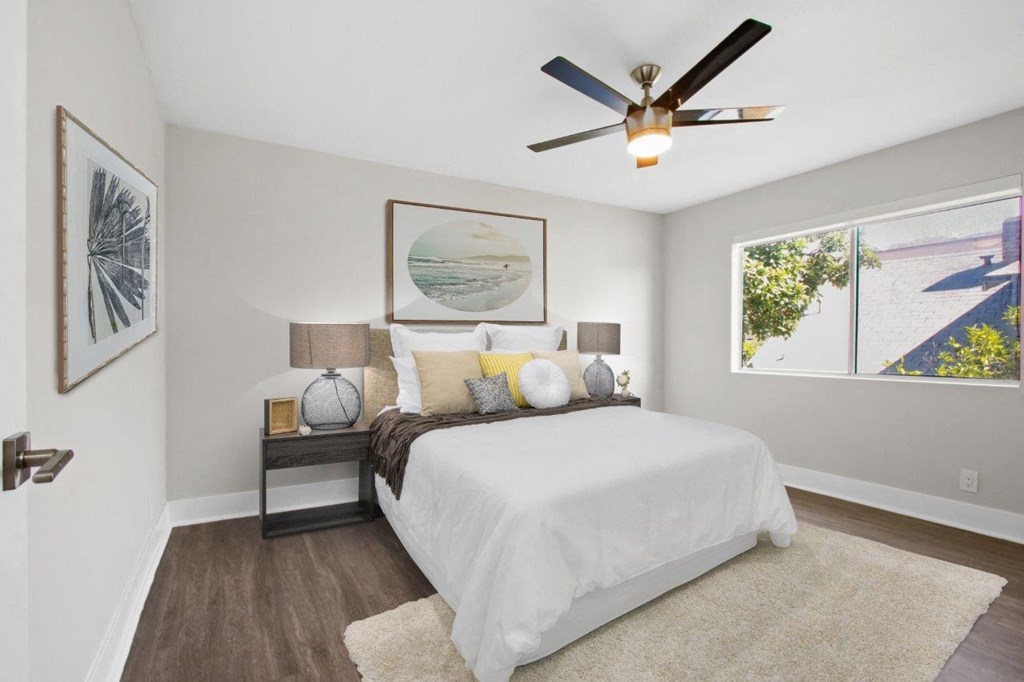 a bedroom with a bed and a ceiling fan