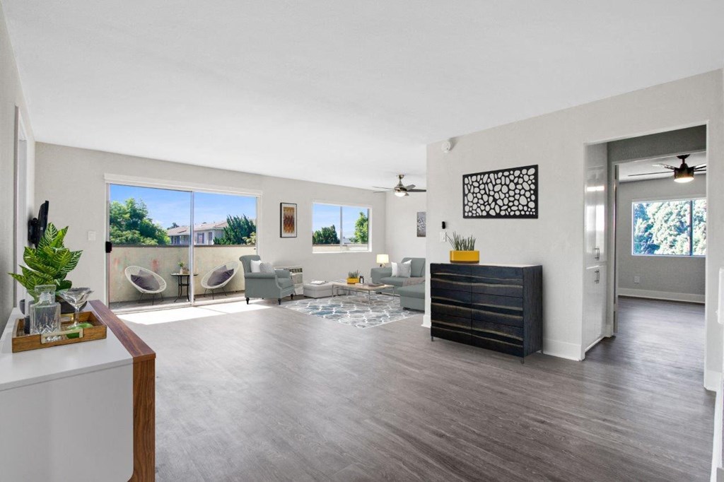 a living room with a couch and a tv and a door to a balcony