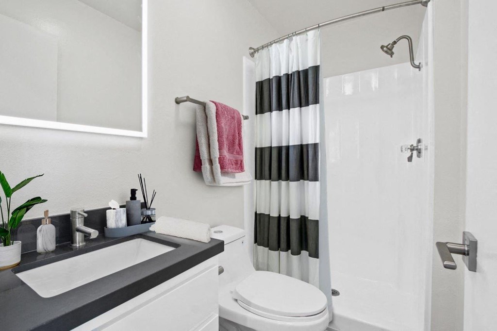 a white bathroom with a black and white shower curtain