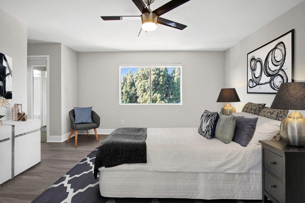a bedroom with a large bed and a ceiling fan