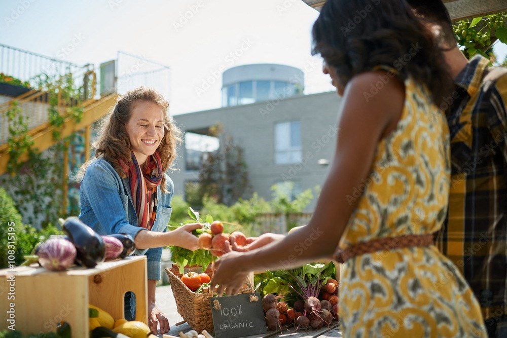 two women buying fruits and vegetables at an outdoor market at Darlington Apartments, Los Angeles, CA