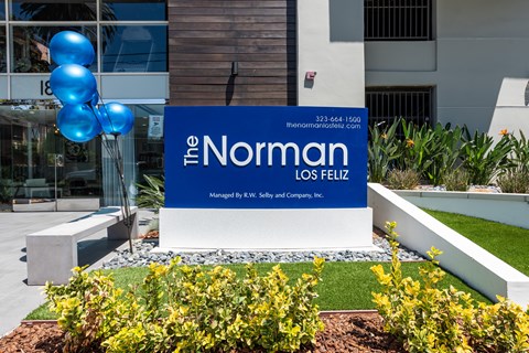 A sign for The Norman Los Fielz is displayed in front of a building.