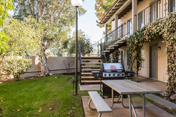 a backyard with a picnic table and a grill