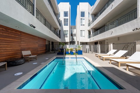 A swimming pool in a courtyard surrounded by buildings.
