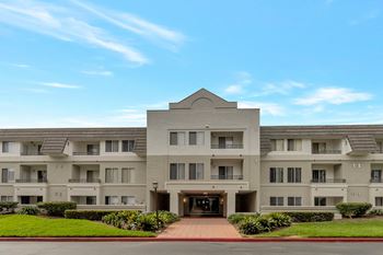 a large apartment building with a blue sky in the background at Nobel Court, San Diego, California