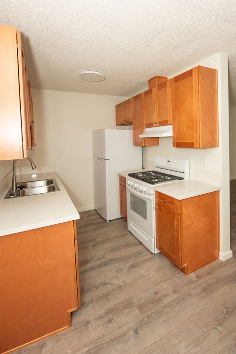A kitchen with wooden cabinets and a white refrigerator.