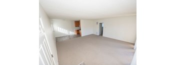 A large empty room with a door and a window.