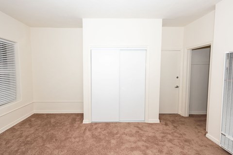 A room with a white door and carpeted floor.