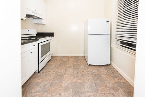 A kitchen with a white fridge, stove and oven.