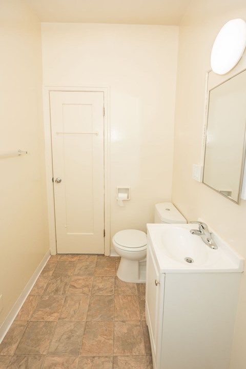 A white toilet and sink in a small bathroom.